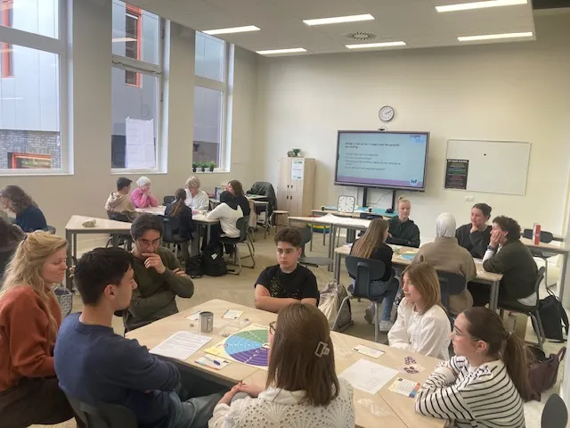 Kleinere groep tijdens een SOL-training met spelmateriaal op tafel